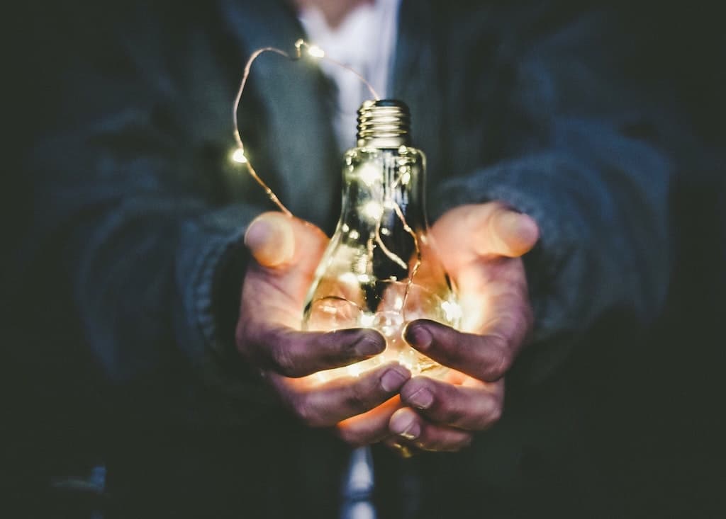man holding a light bulb to represent how to start an online business with an idea and a vision