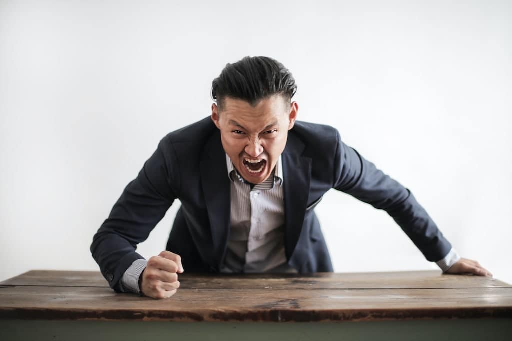 yelling man in a suit not showing good self-discipline at work